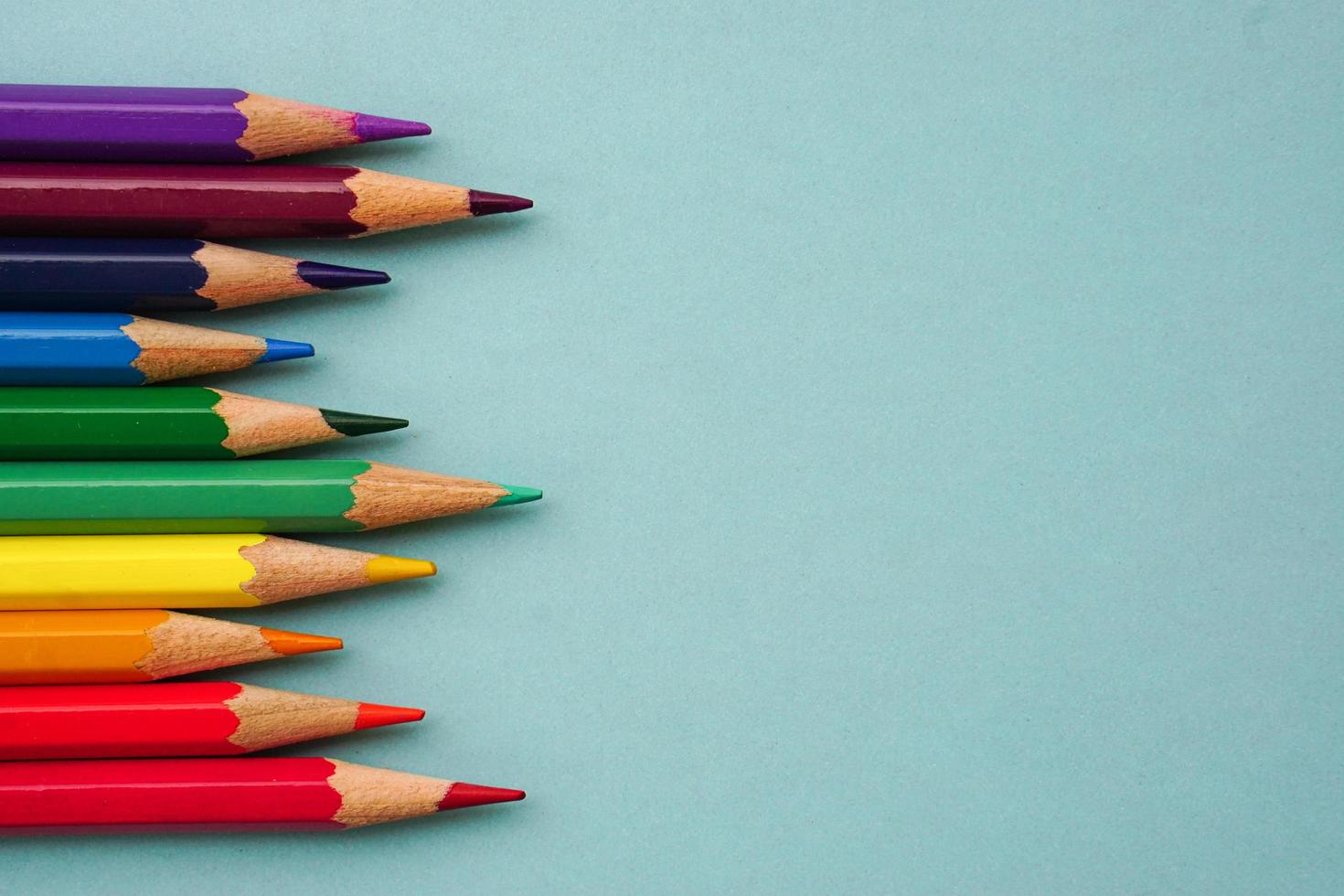 Top view of colored pencils or pastel on blue background. Learning, study and presentation concept. photo