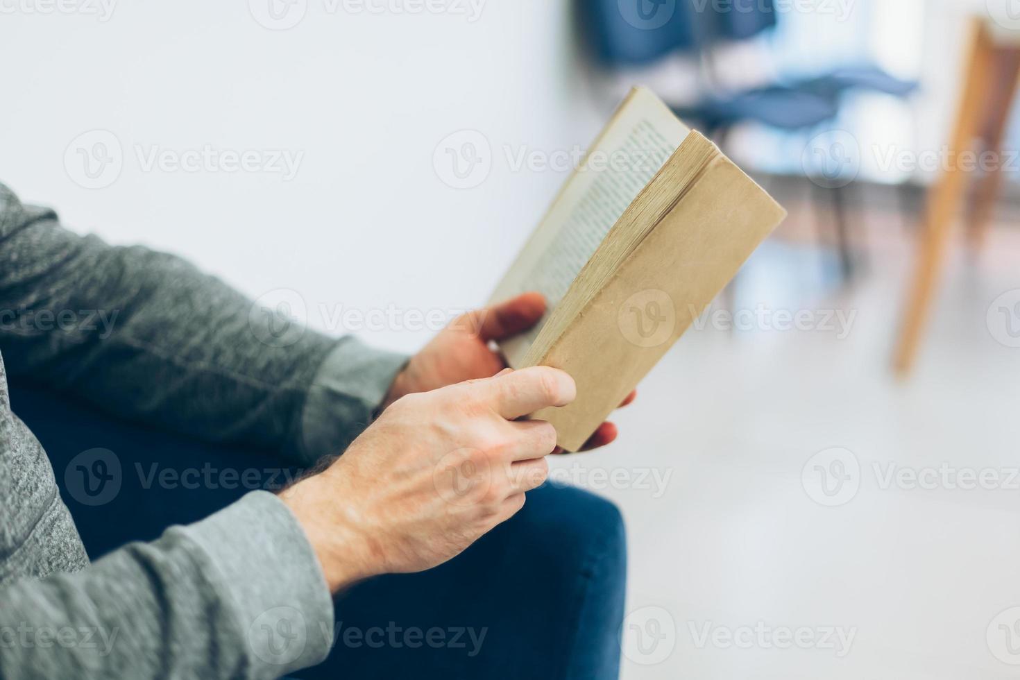 Young man reading open old paper book photo