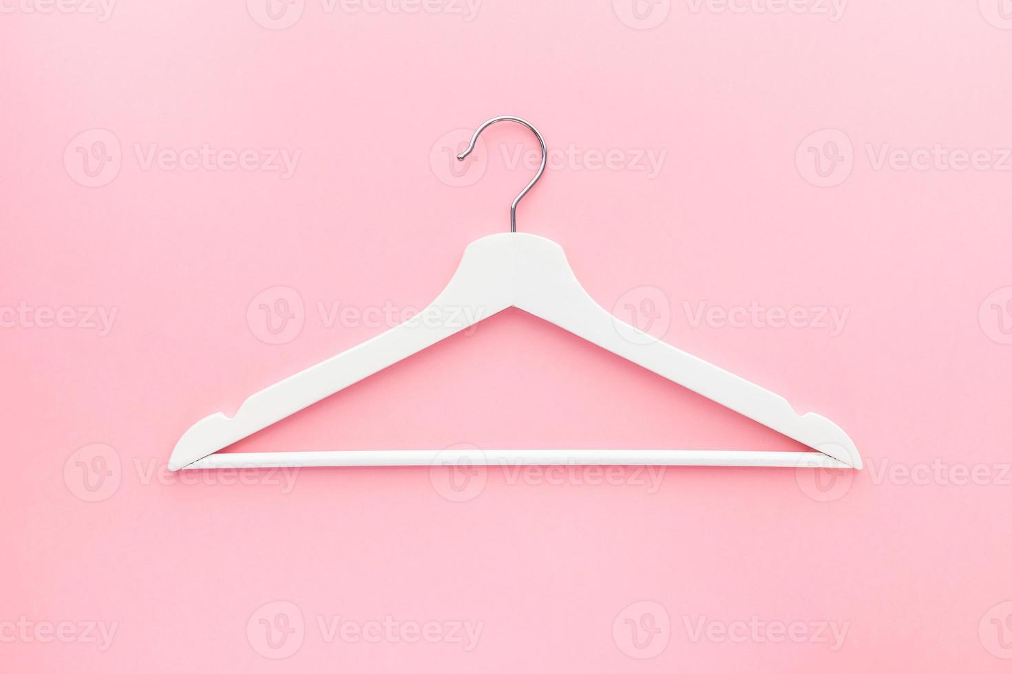 White hangers on pastel pink background photo