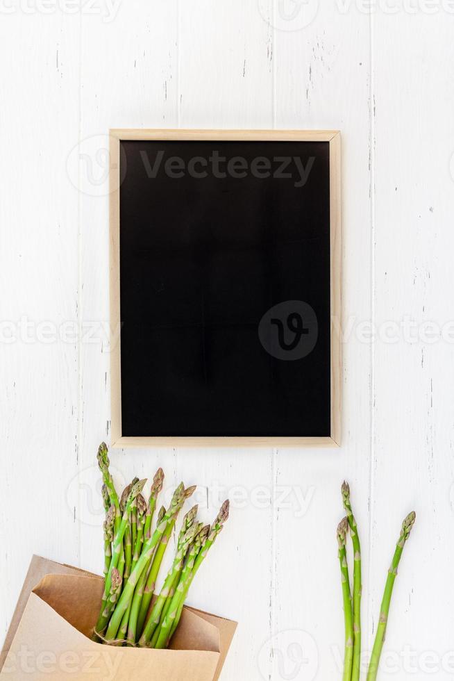 Fresh green asparagus with black chalkboard frame photo