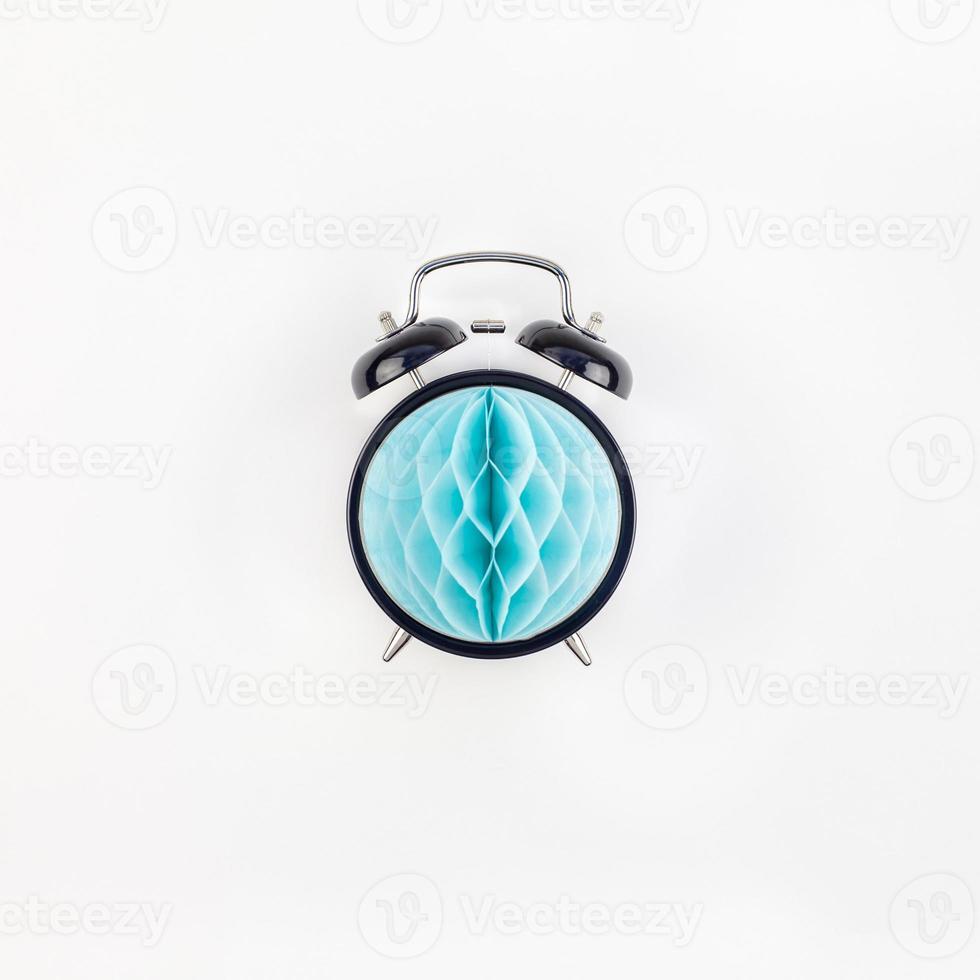 Black alarm clock with blue paper ball concept photo