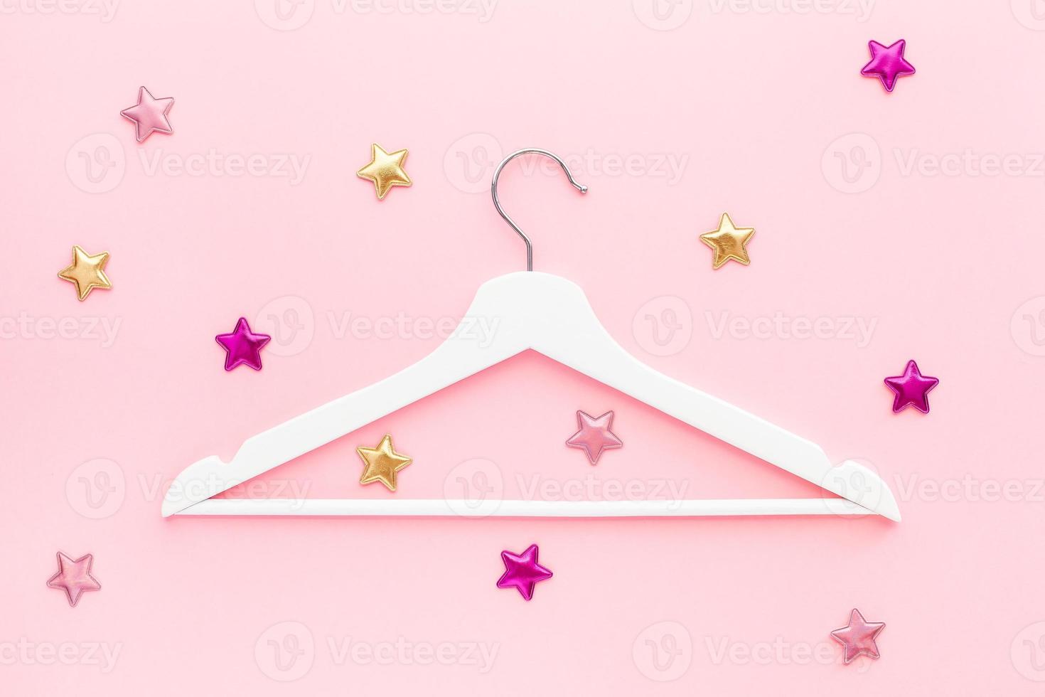 White hangers on pastel pink background photo