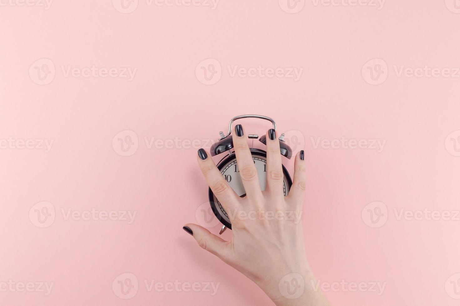 Female hand with alarm clock. Morning concept photo