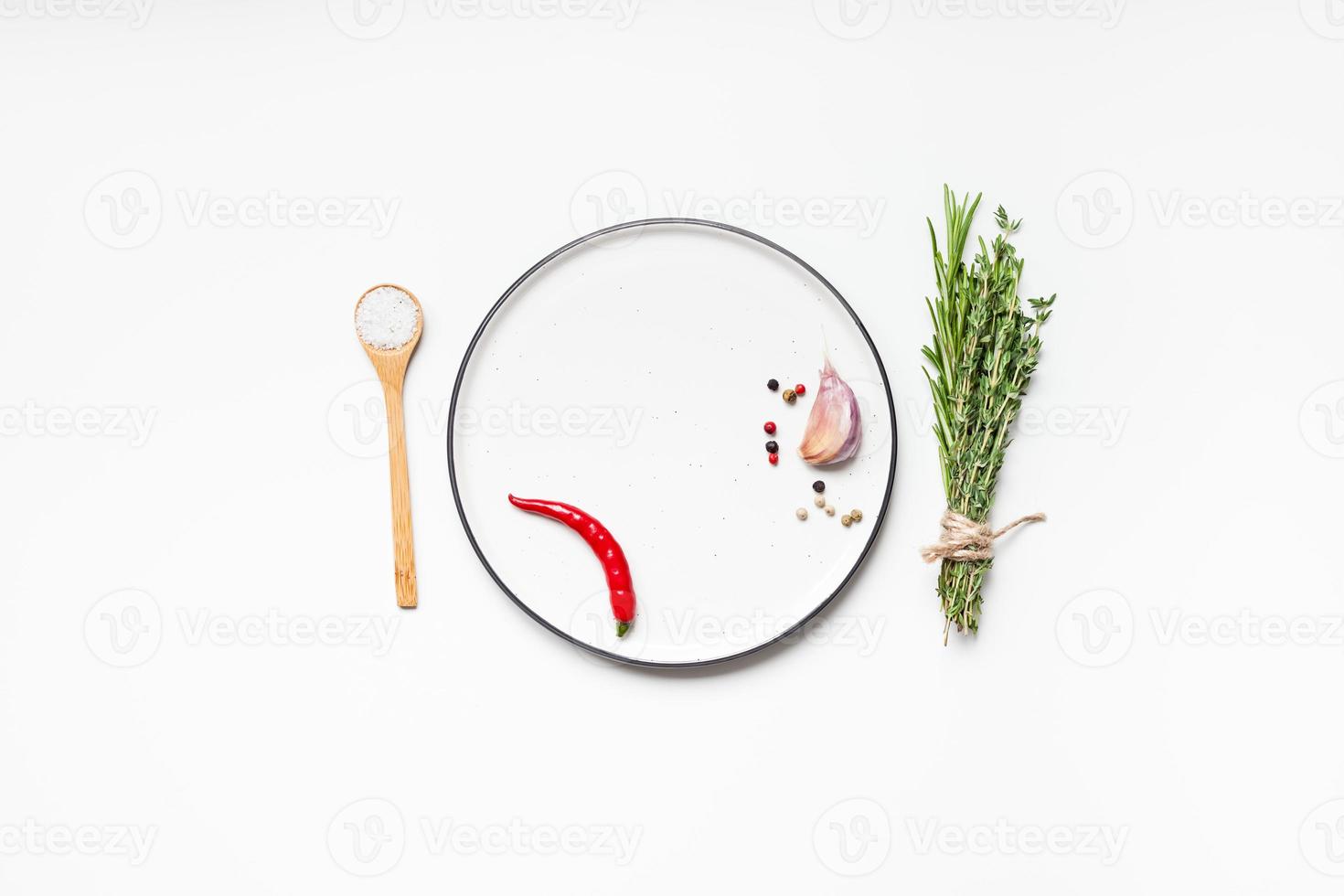 Empty plate with greens herbs and spices around photo