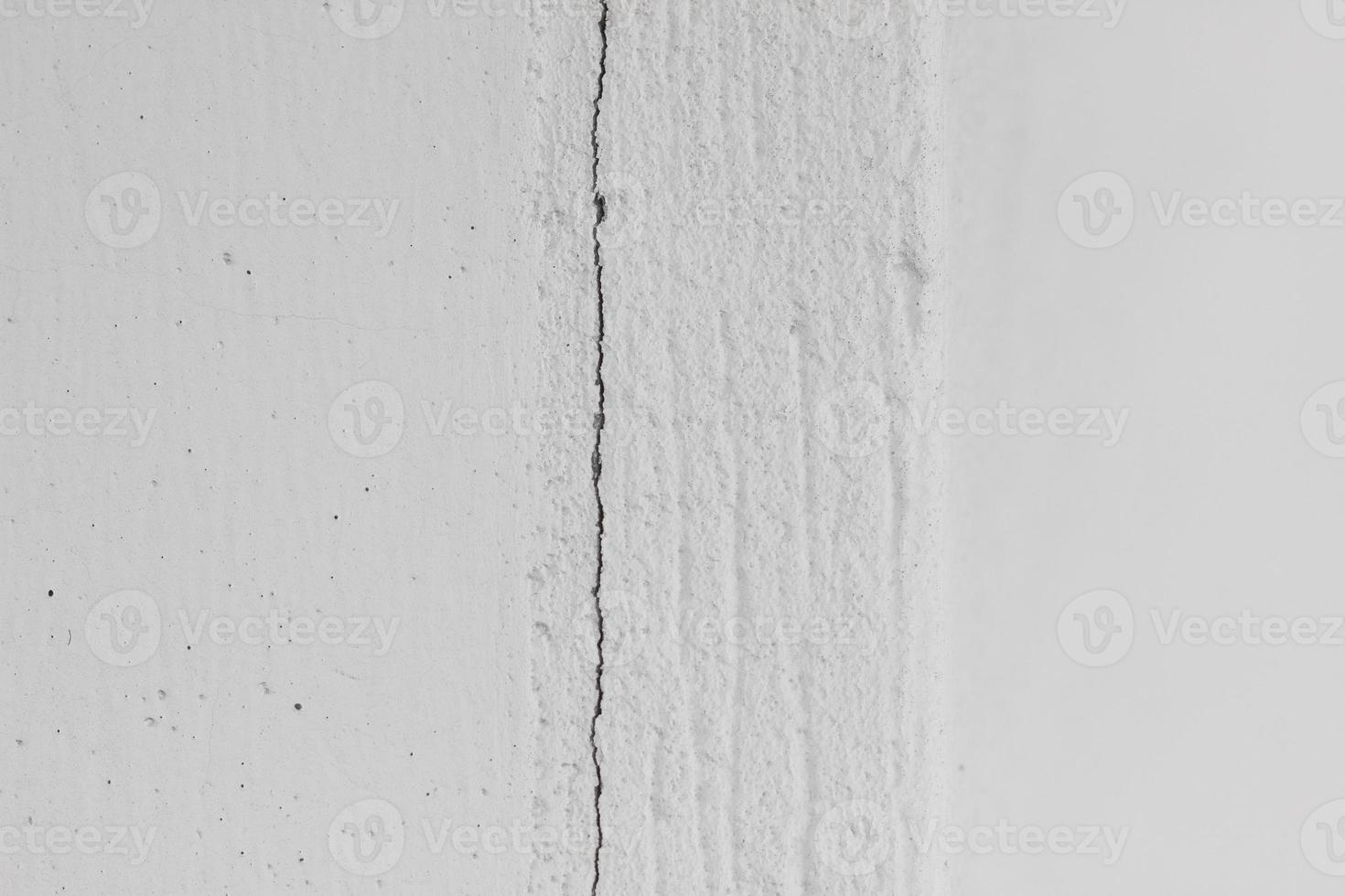 White textured concrete wall with dots and vertical crack, horizontal photo. Shot for abstract background, decorative design element with empty space, wallpaper photo