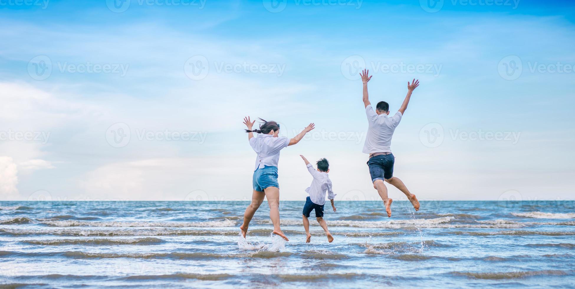 Happy family jumping on the beach photo