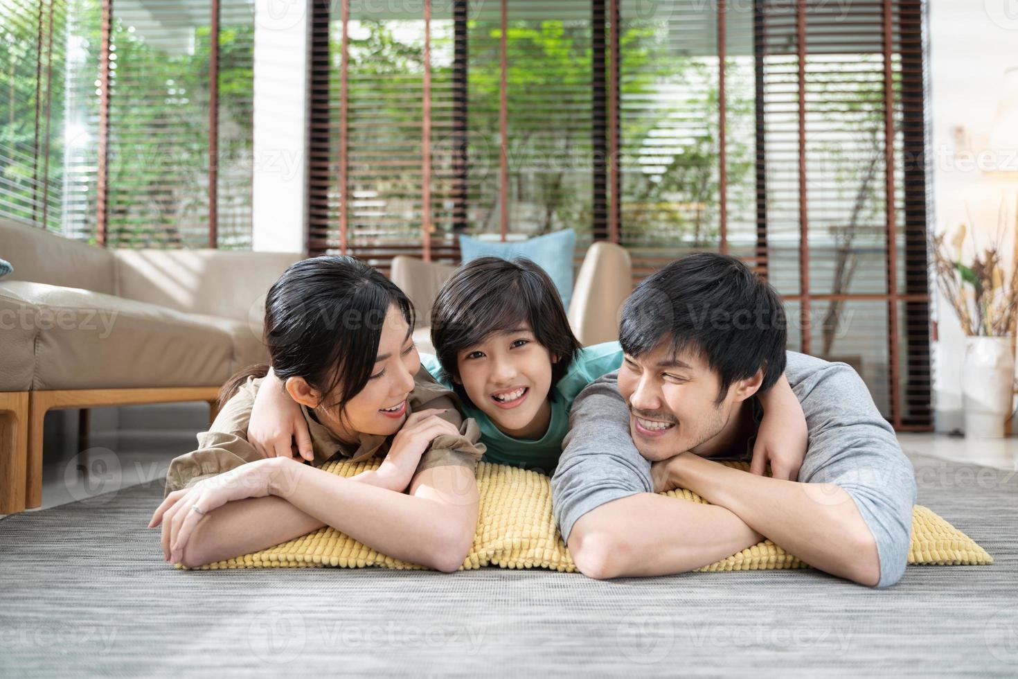 portrait of happy Asian family spending time together on sofa in living room. family and home concept. photo
