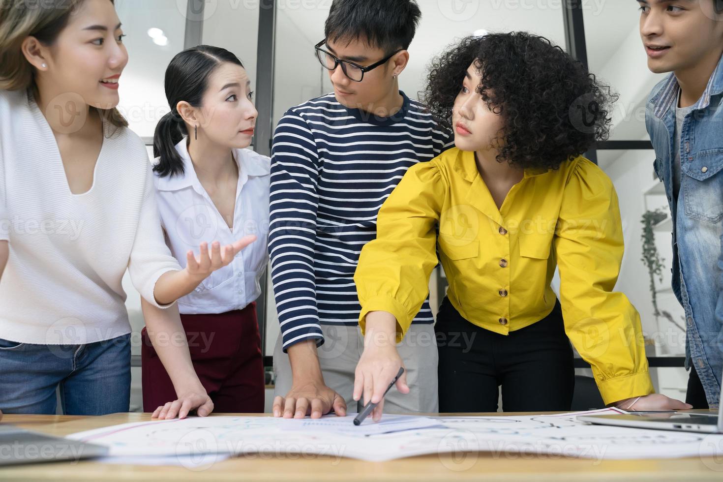 grupo de jóvenes y serios empresarios asiáticos creativos que se reúnen en una oficina moderna para planificar y compartir ideas foto