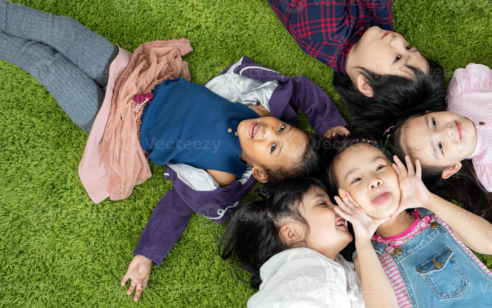 niños felices divirtiéndose. los niños se acuestan juntos foto