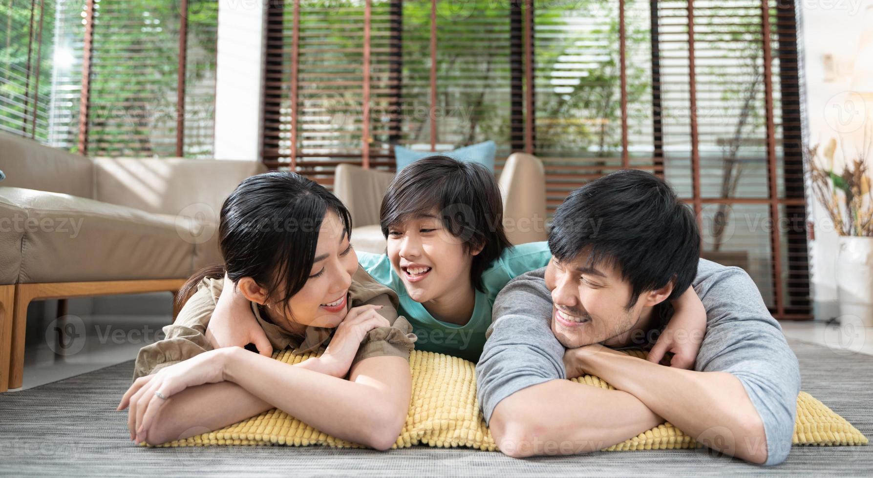 portrait of happy Asian family spending time together on sofa in living room. family and home concept. photo