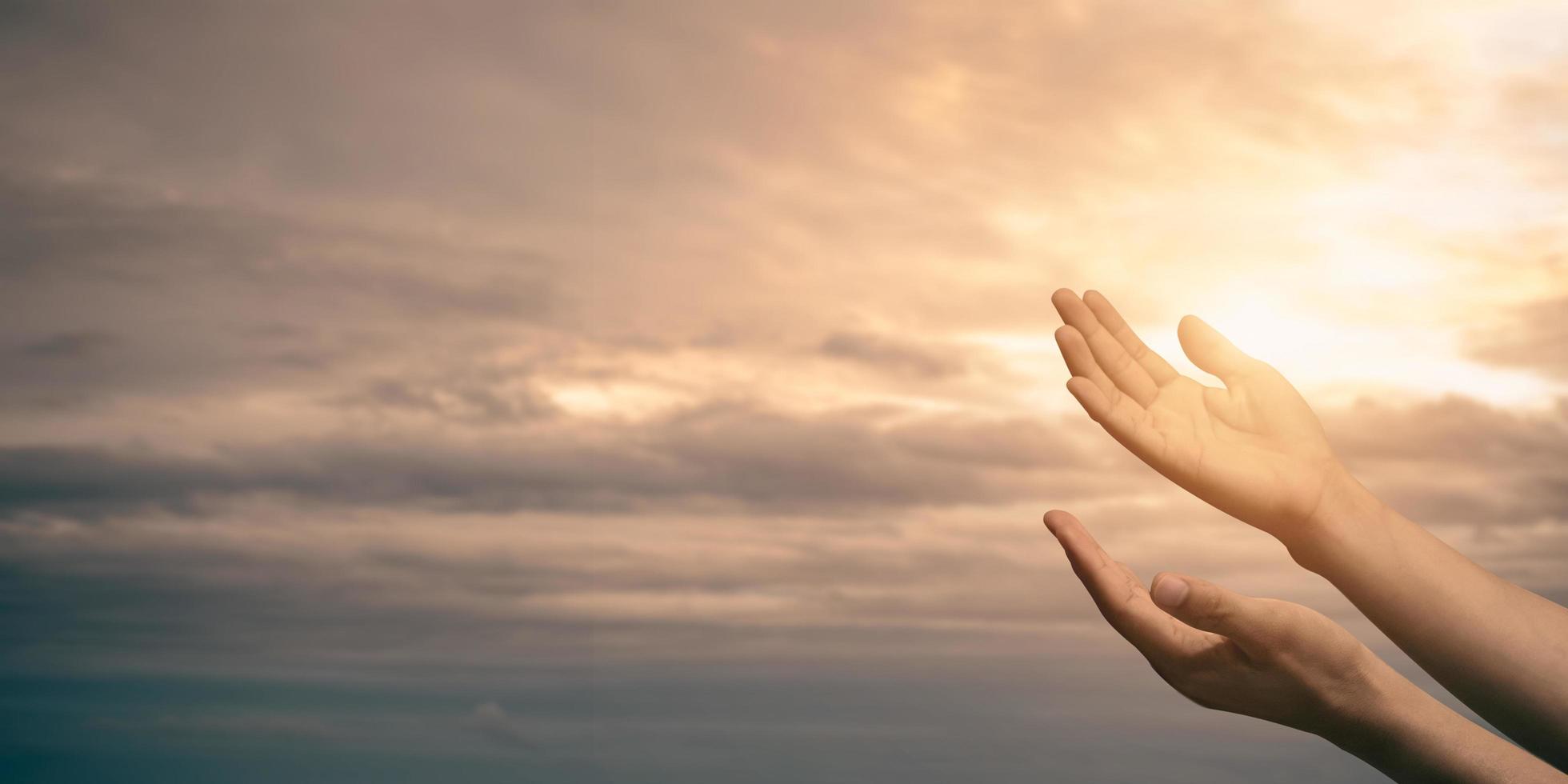 Woman hands praying for blessing from god with sunlight on sunset background. photo