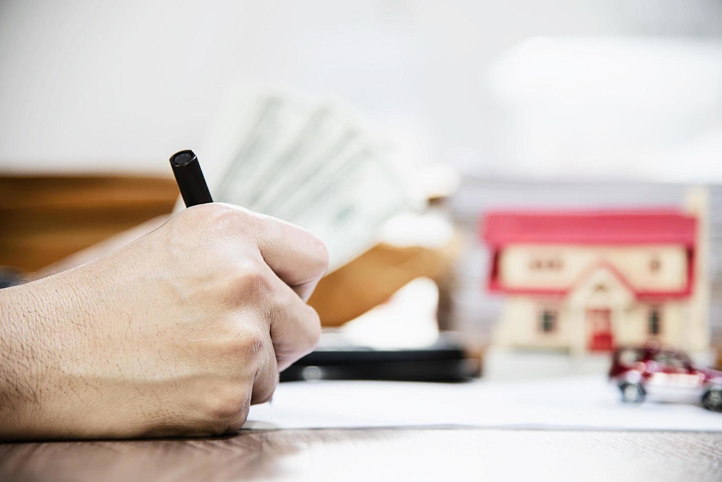 Business man counting money dollar note calculating home and car loans - personal financial insurance lifestyle real estate concept photo