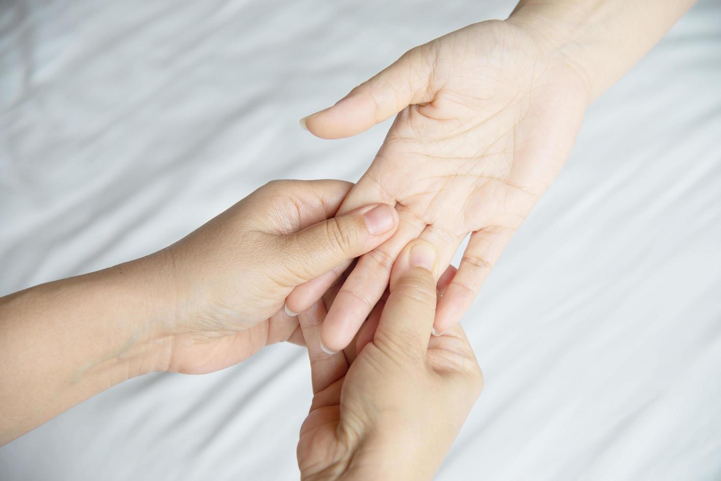 Hand spa massage over clean white bed background - people relax with hand massage service photo