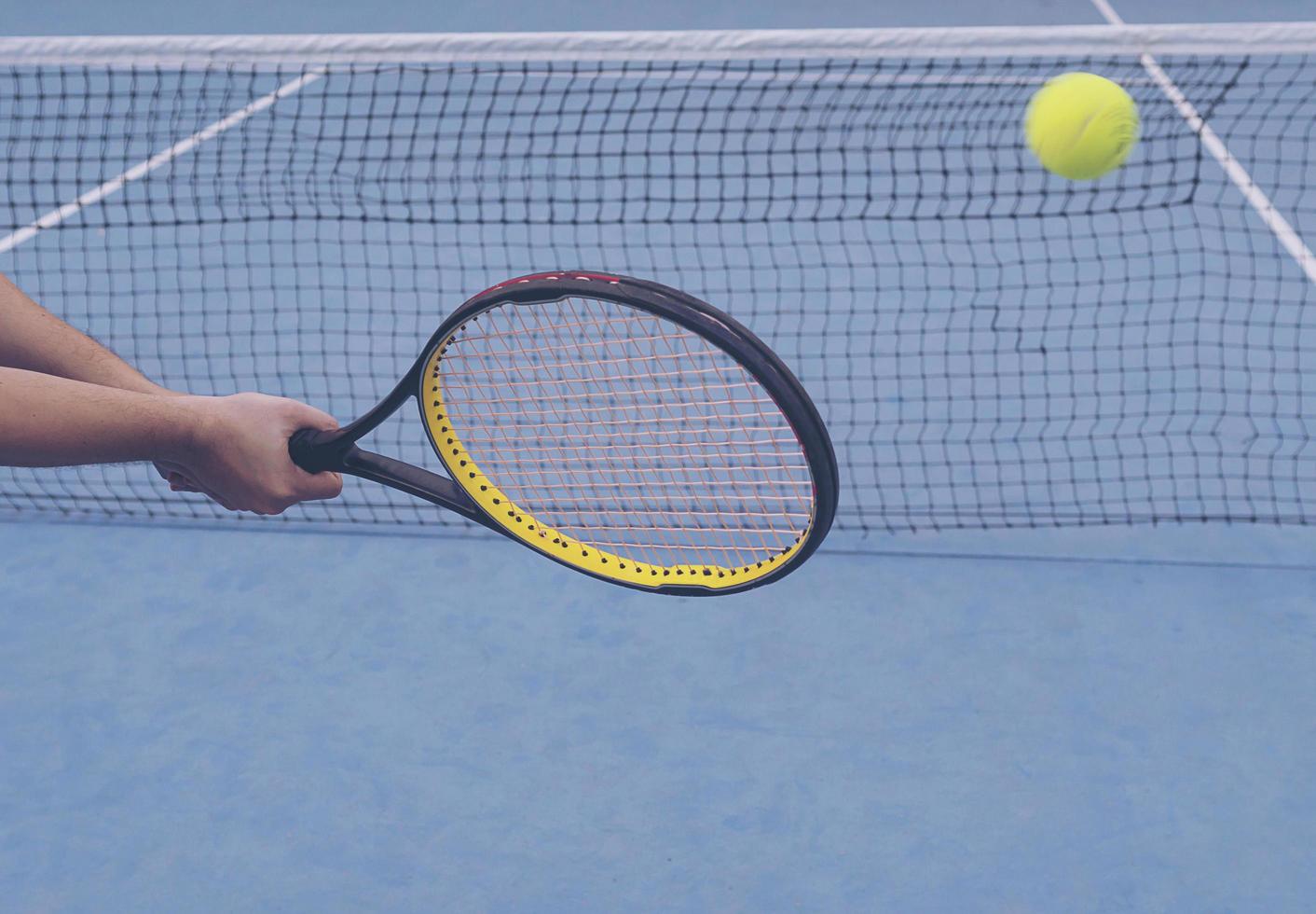 Man holding racket about to hit a ball in tennis court photo