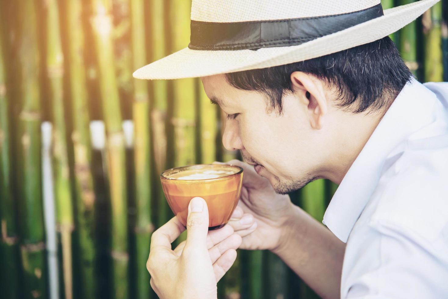 Casual Asian man drink hot coffee happily in nature - people with coffee in nature concept photo