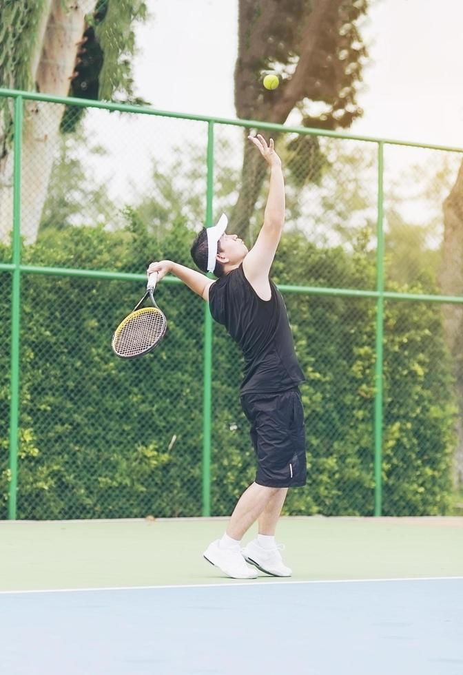 Tennis player is serving during a match photo