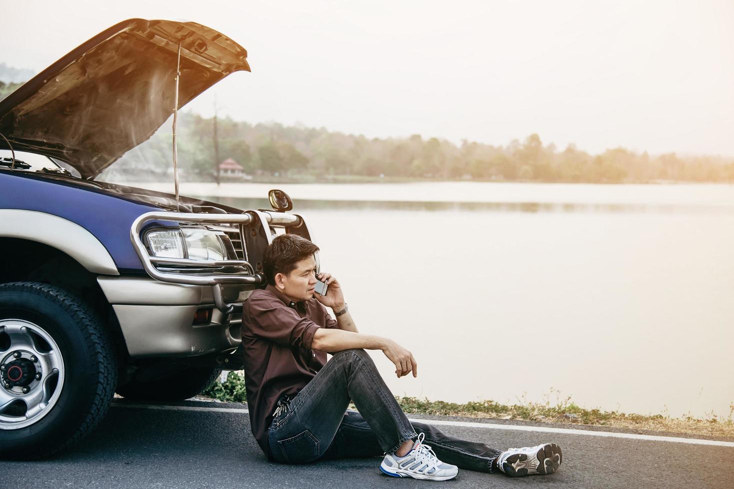 Man try to fix a car engine problem on a local road Chiang mai Thailand - people with car problem transportation concept photo