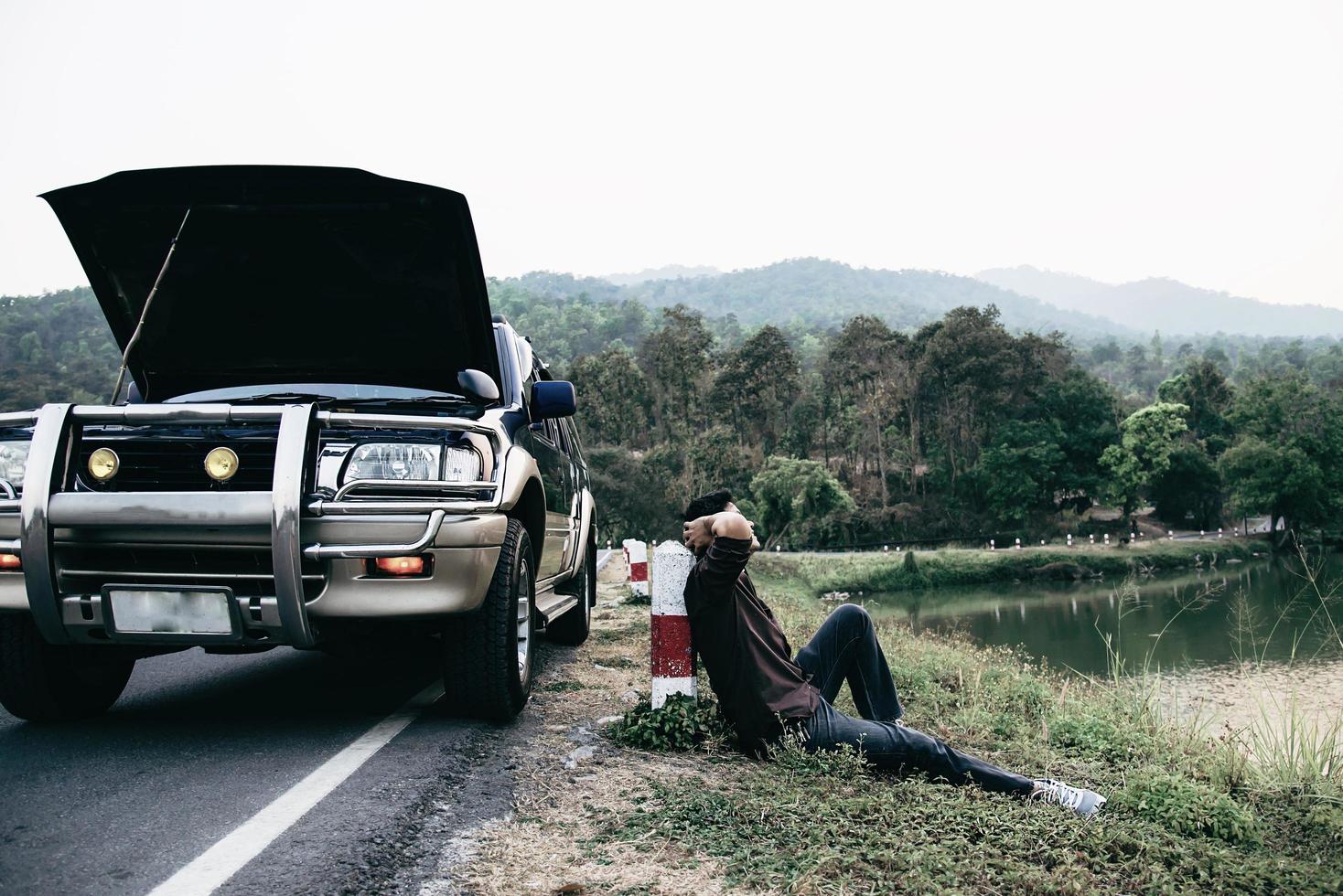 Man try to fix a car engine problem on a local road Chiang mai Thailand - people with car problem transportation concept photo