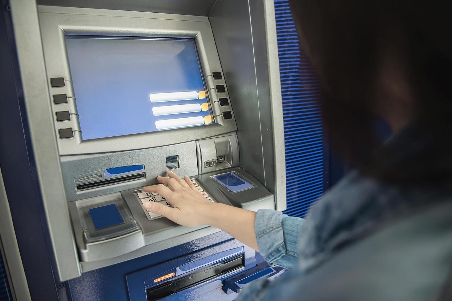 People waiting to get money from automated teller machine - people withdrawn money from ATM concept photo