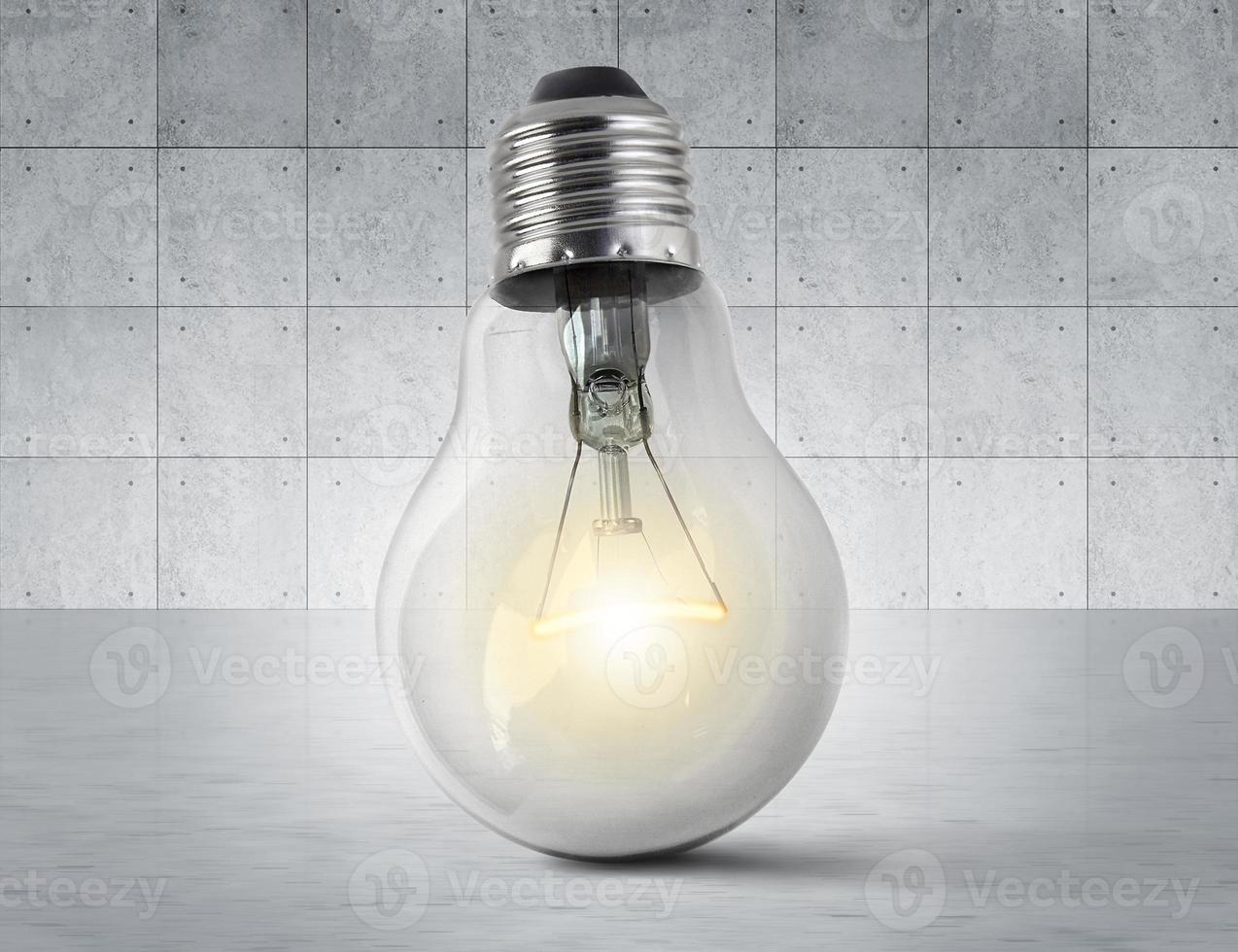 Light bulb on concrete room floor photo