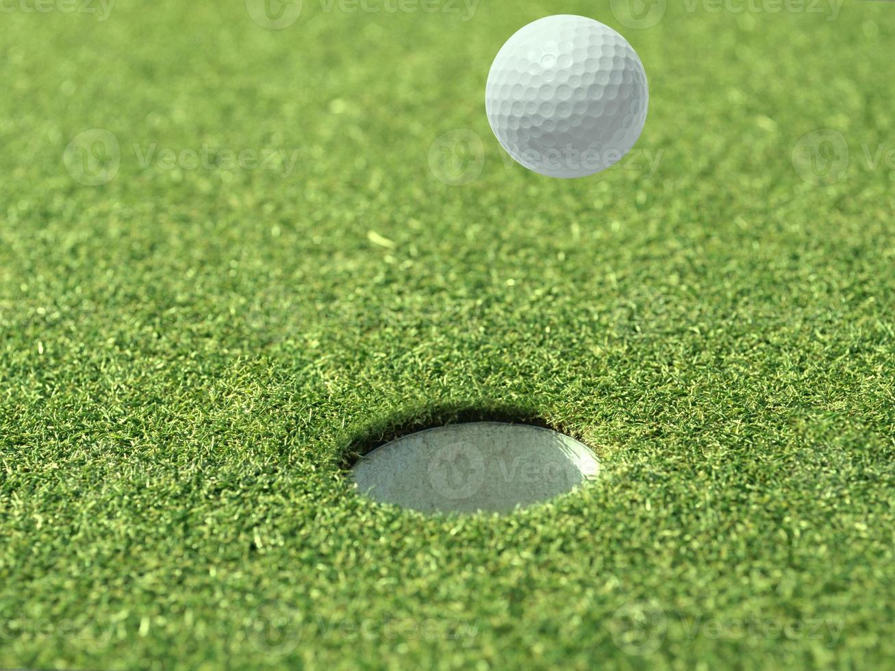 Golf ball floating in the air on a golf course photo