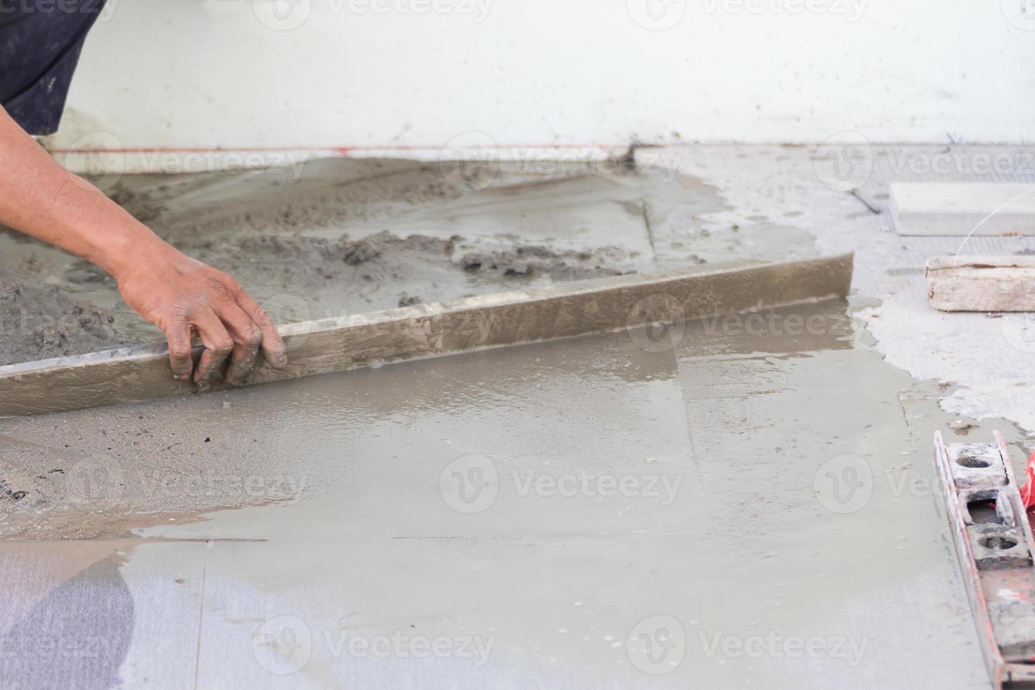 Builder worker plastering concrete at floor photo