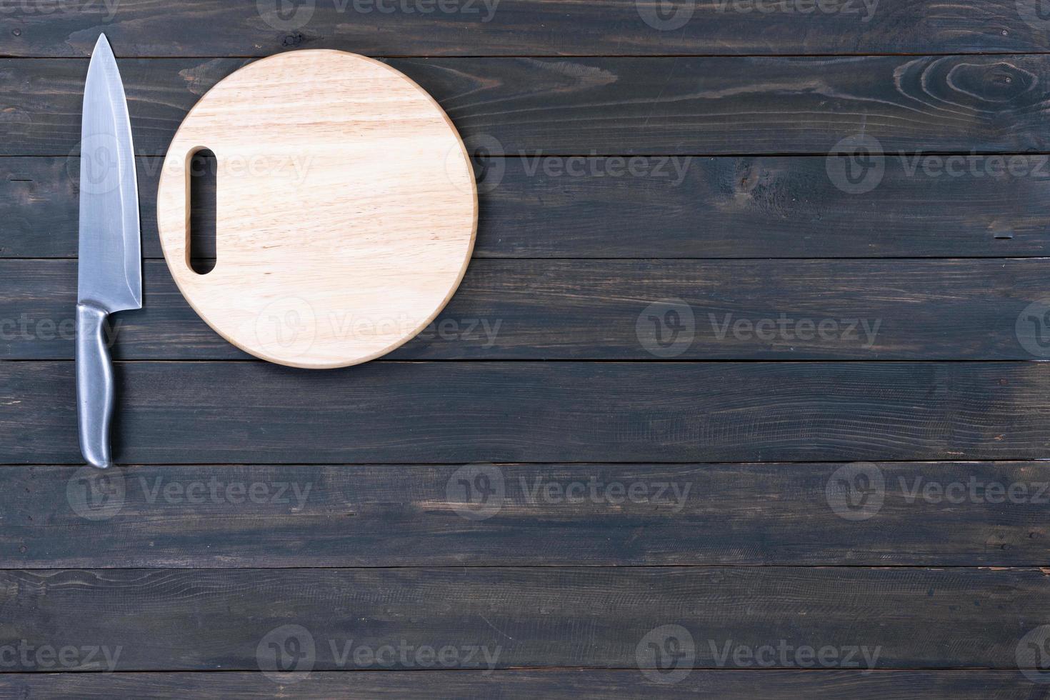 cuchillo de cocina y tabla de cortar vacía redonda de madera foto