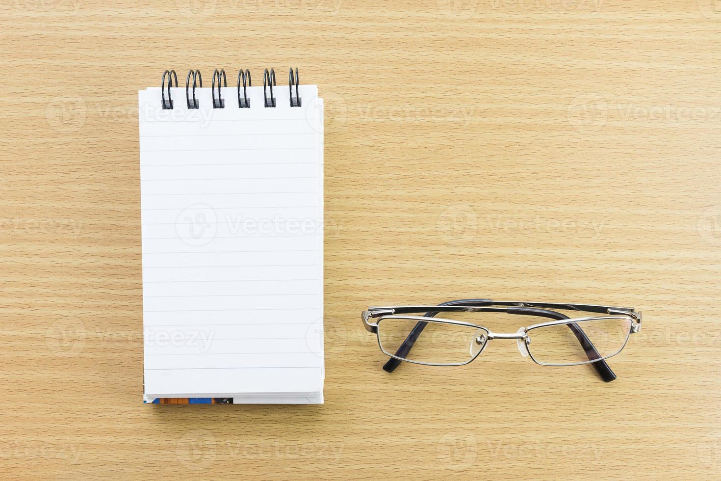 Eyeglasses and Notepad with blank page photo