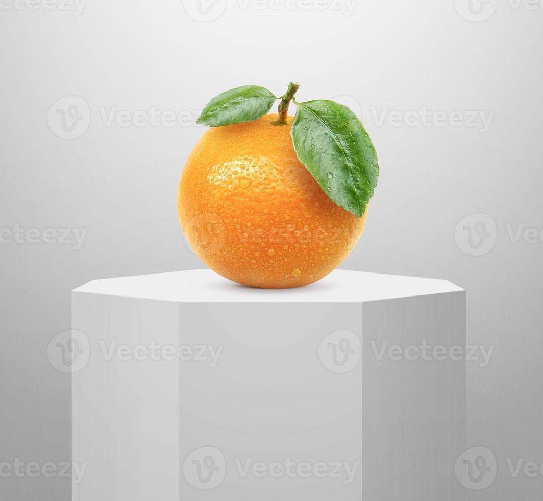 Orange fruit, on Shiny white round pedestal podium photo