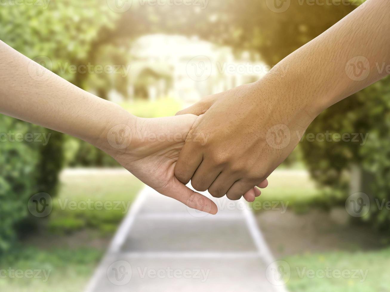 Image of a couple holding hands in a park photo