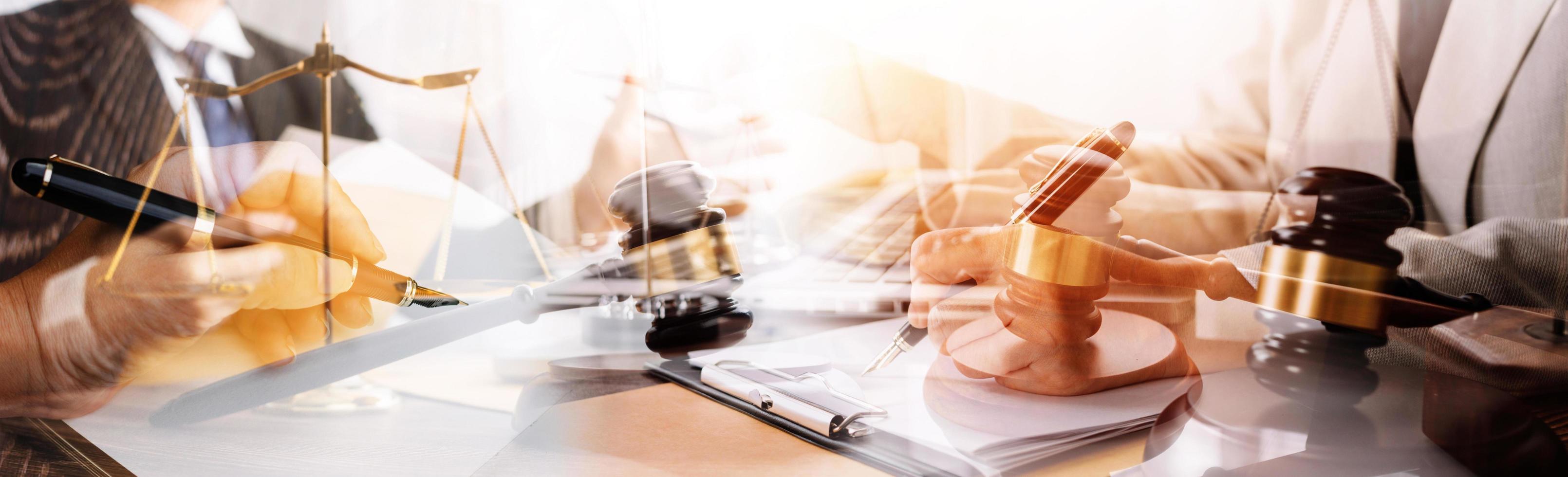 Justice and law concept.Male judge in a courtroom with the gavel, working with, computer and docking keyboard, eyeglasses, on table in morning light photo