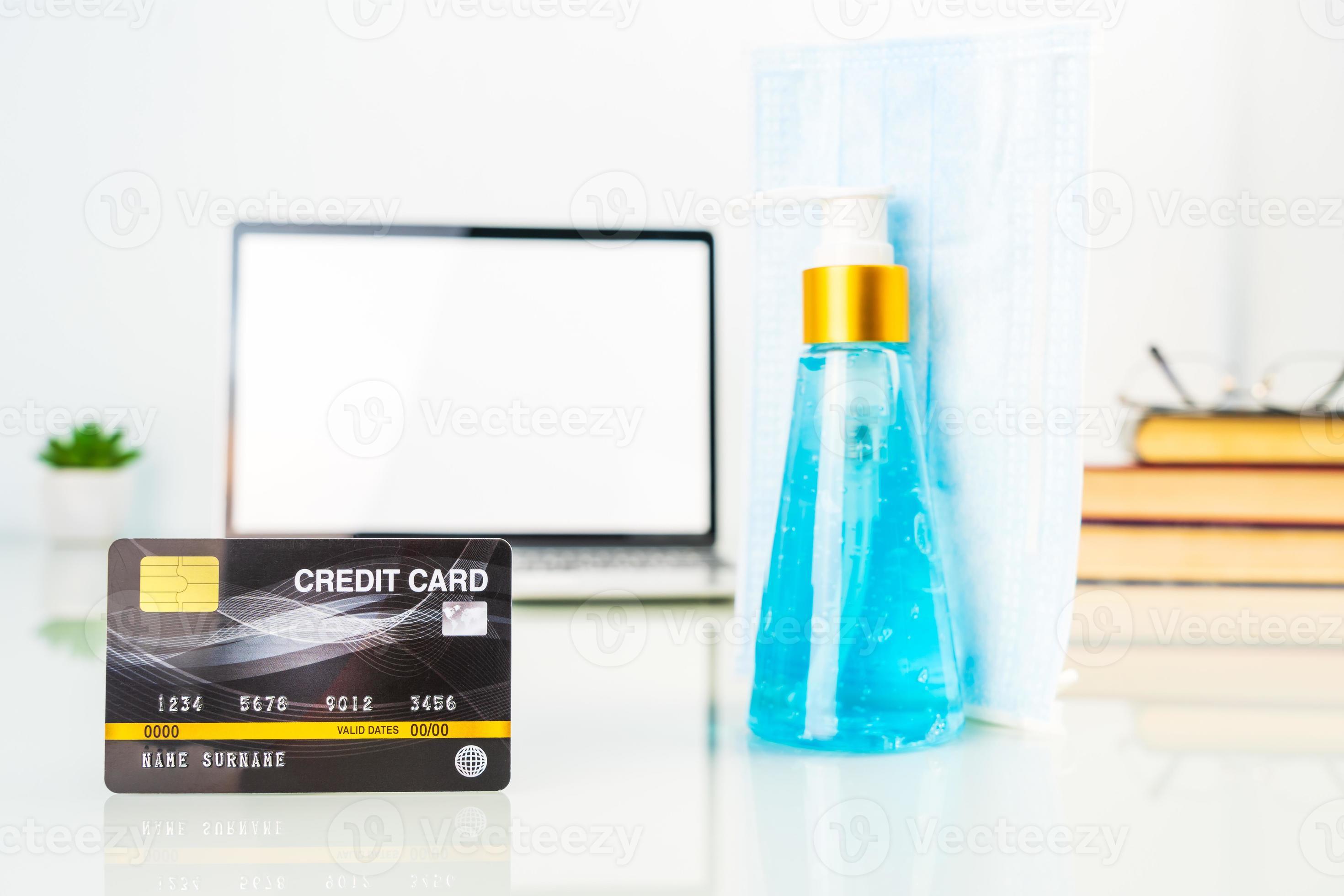 Credit card front of laptop screen with hand sanitizer and surgical