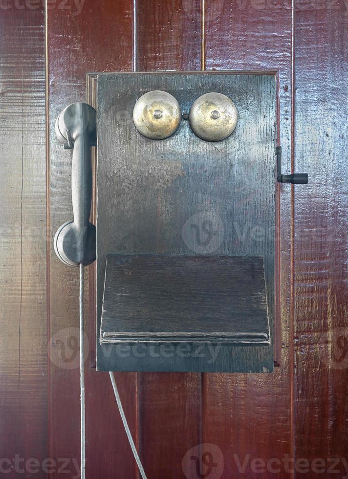 Antique old telephone hang on wooden wall photo