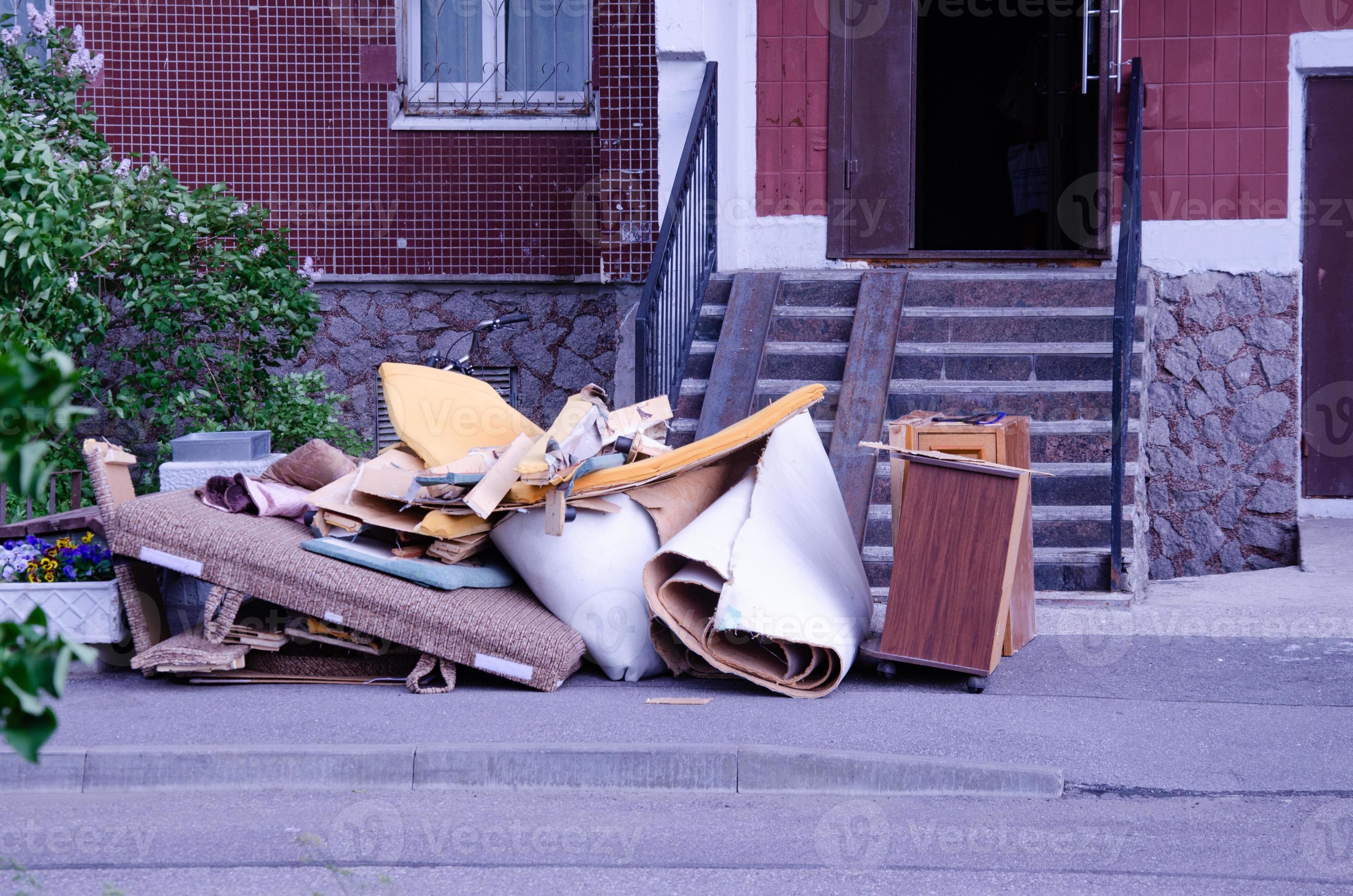 throw out old broken furniture in front of the entrance. garbage in front of the house 10222609