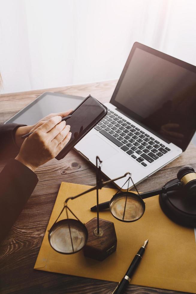 Justice and law concept.Male judge in a courtroom with the gavel, working with, computer and docking keyboard, eyeglasses, on table in morning light photo
