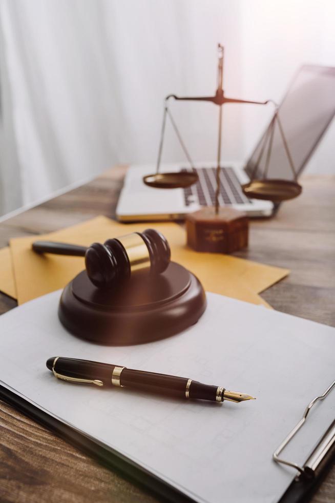 Justice and law concept.Male judge in a courtroom with the gavel, working with, computer and docking keyboard, eyeglasses, on table in morning light photo