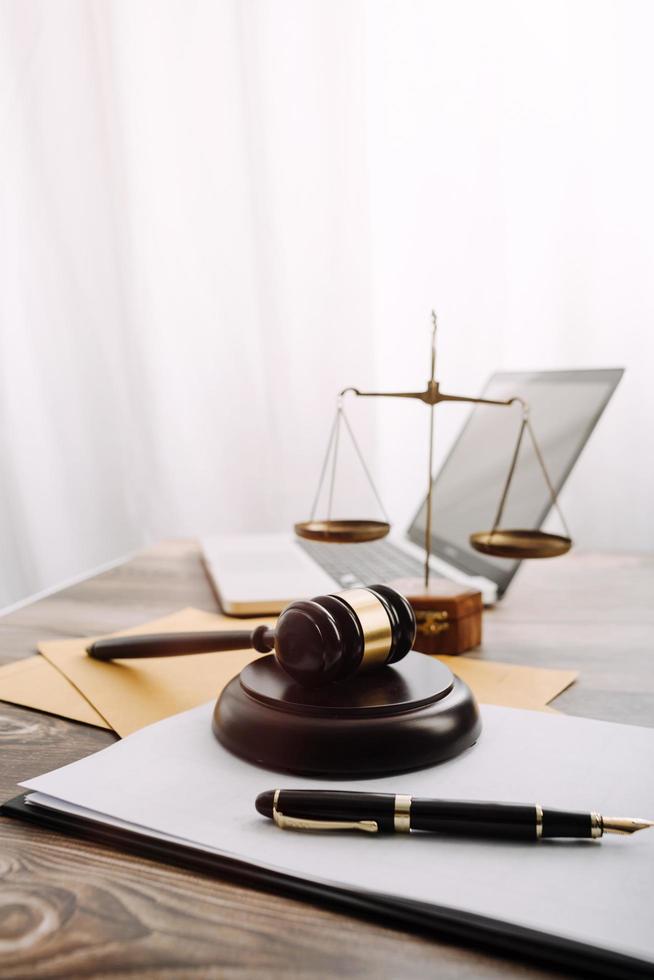 Business and lawyers discussing contract papers with brass scale on desk in office. Law, legal services, advice, justice and law concept picture with film grain effect photo