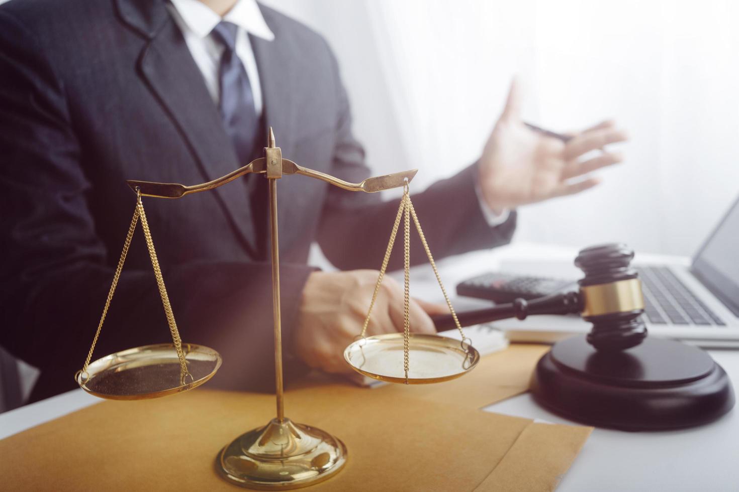 Business and lawyers discussing contract papers with brass scale on desk in office. Law, legal services, advice, justice and law concept picture with film grain effect photo