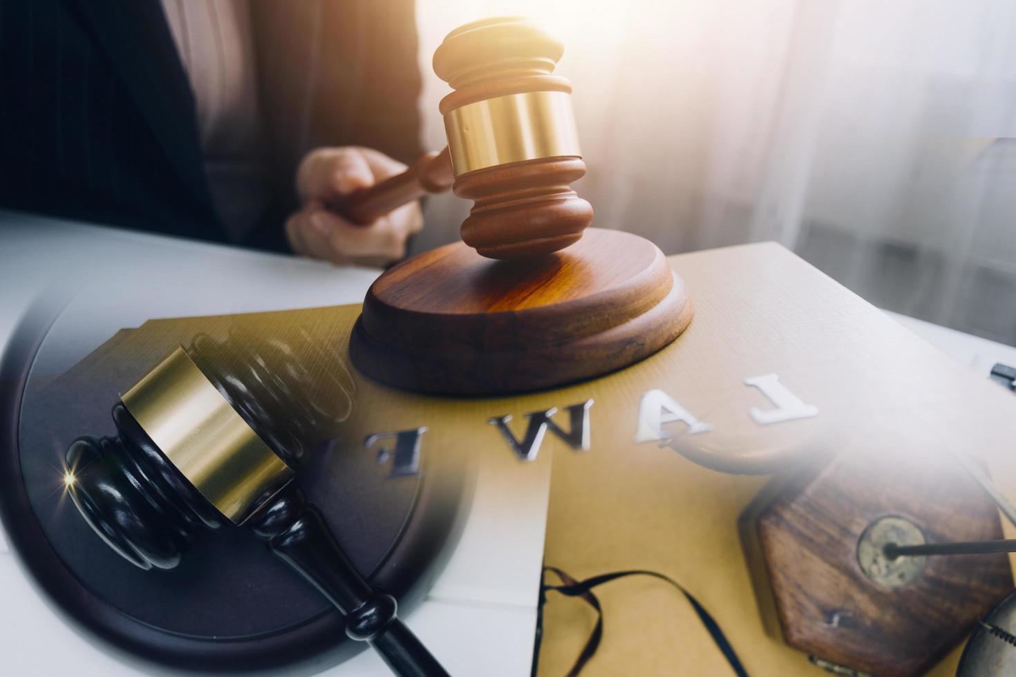 Business and lawyers discussing contract papers with brass scale on desk in office. Law, legal services, advice, justice and law concept photo