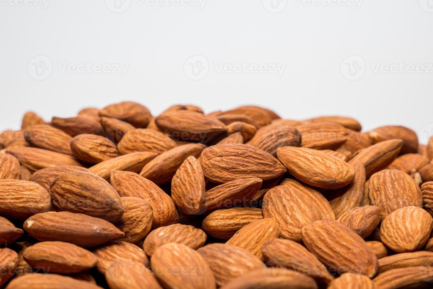 Whole almond nuts on the white background. Healthy vegetarian snack. Close-up photo. Copy-space for your text. High quality photo