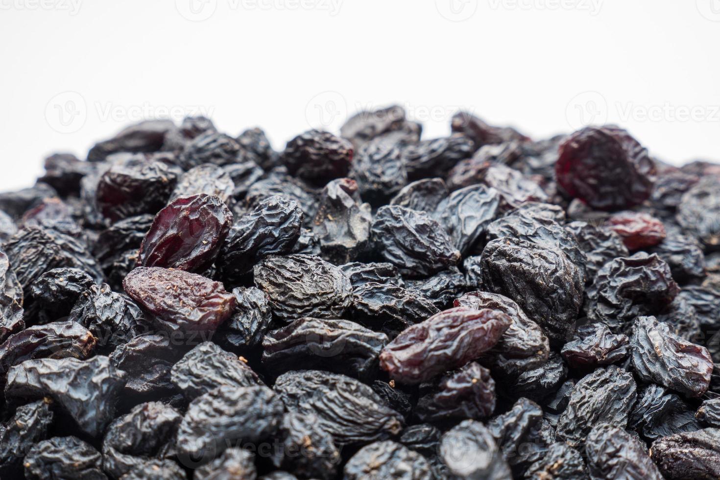 Black raisins on the white background. Vegetarian healthy snack. Organic food. Vegetable diet. photo