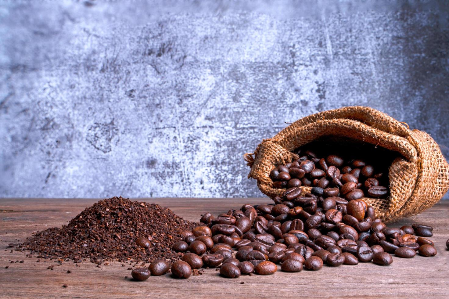 Coffee beans and ground powder  on the old wooden background.soft focus. photo