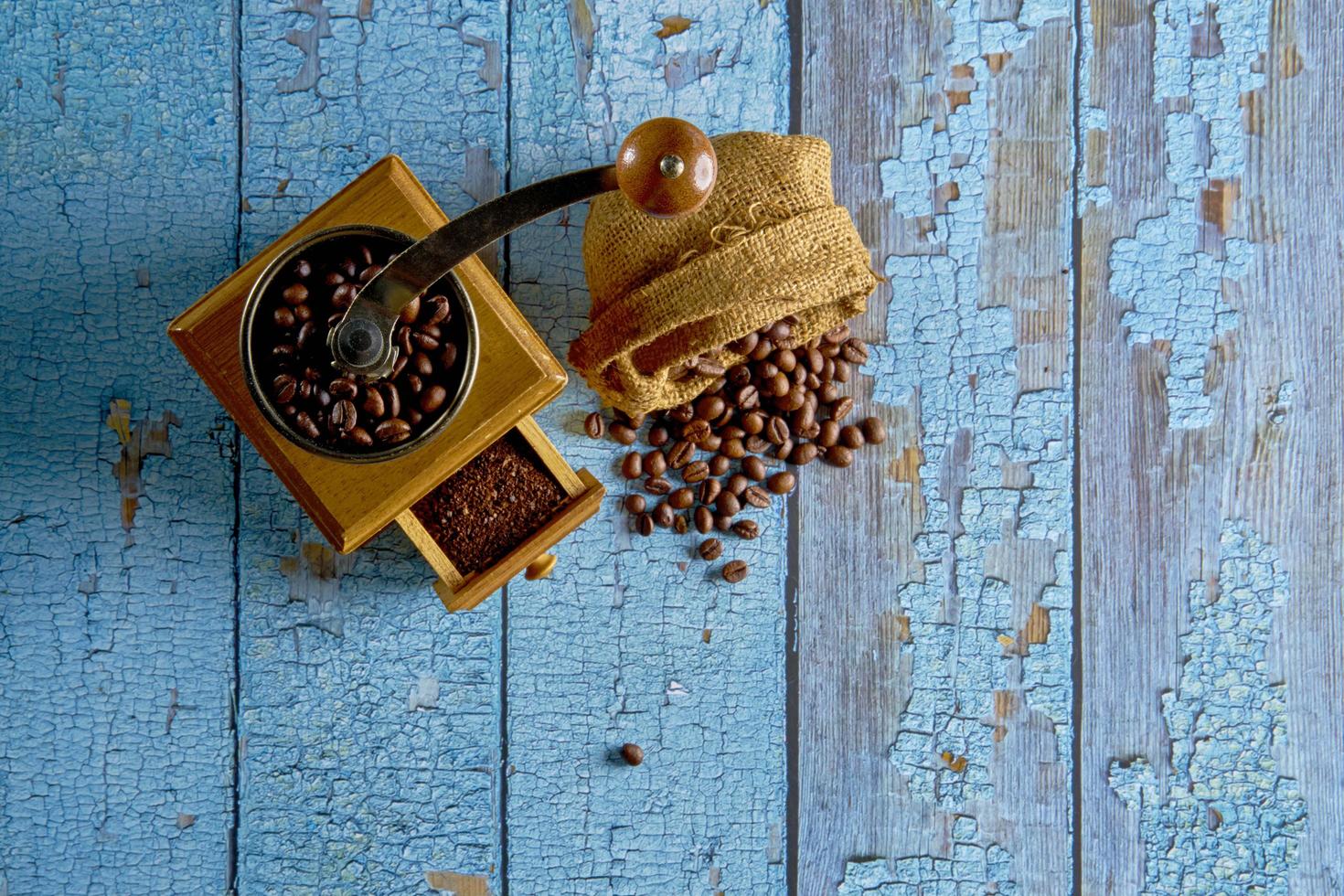 Vintage coffee grinder.Old retro hand-operated wooden and metal coffee grinder.Manual coffee grinder for grinding coffee beans. on the old wooden background.soft focus. photo