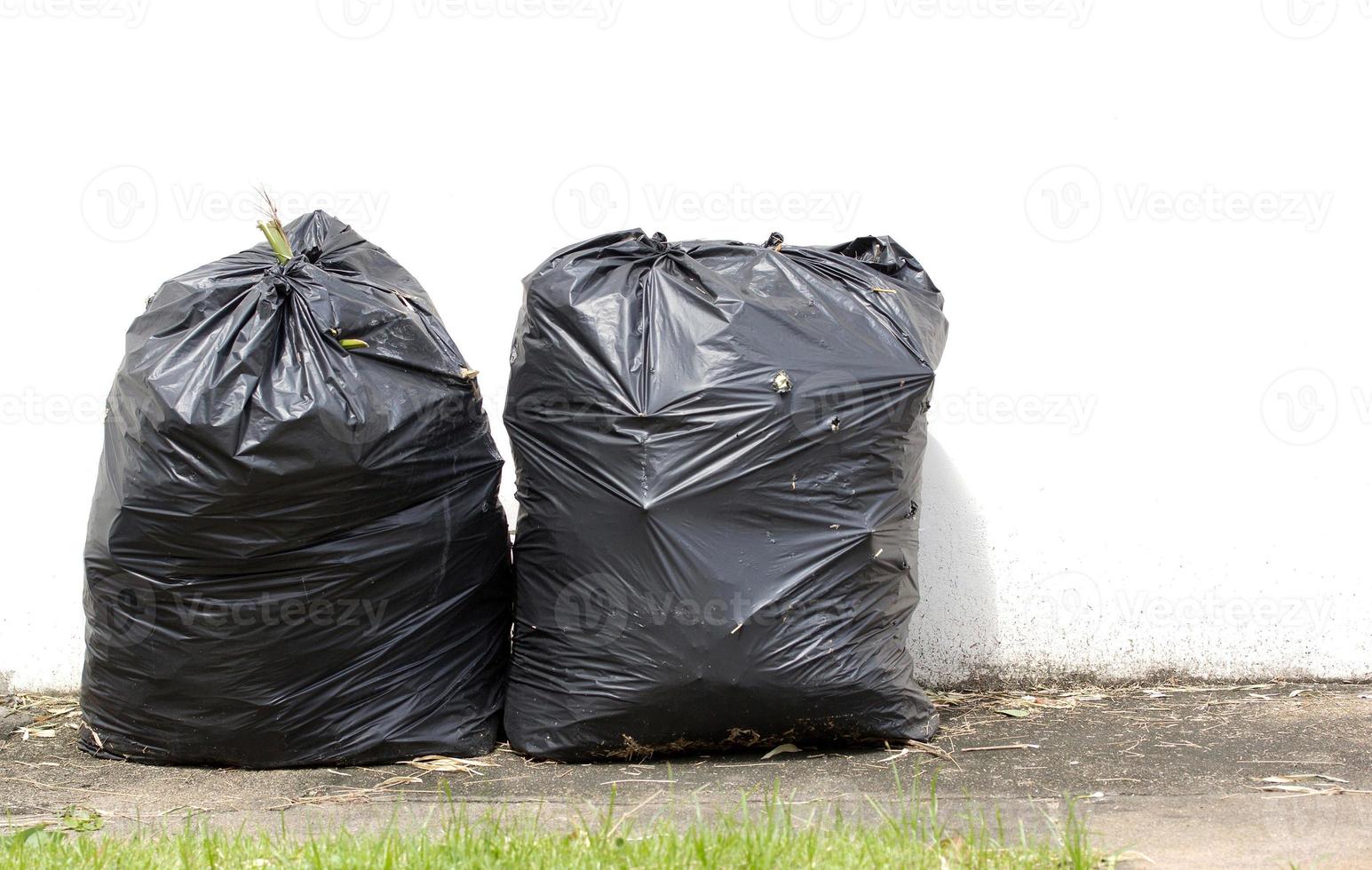 bolsas de basura negras en la pasarela y fondo de pared blanca foto