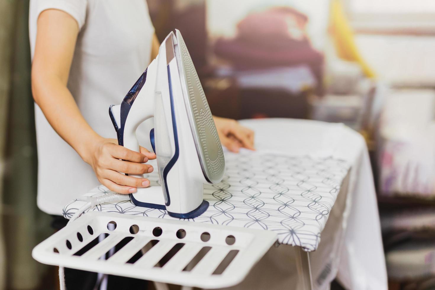 Housewife ironing clothes on an ironing board. photo