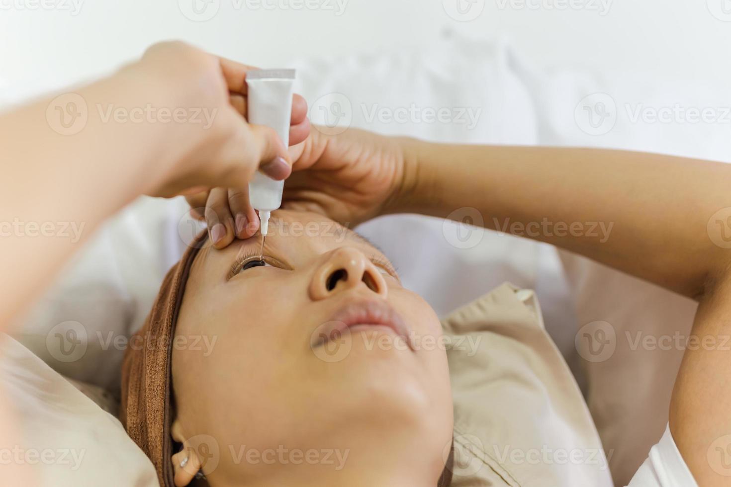 Asian woman uses eye drops for eye treatment. photo