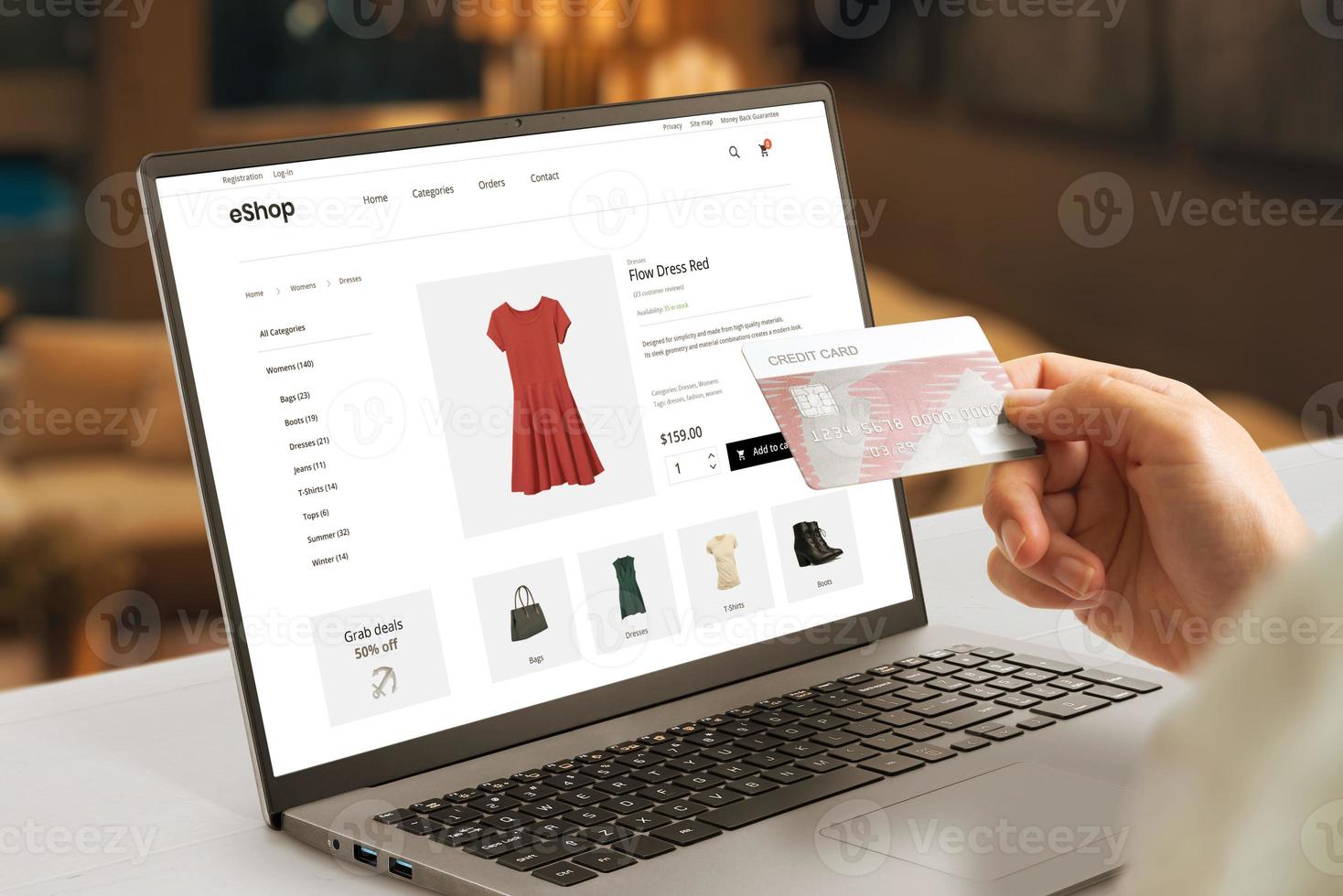 Shopping online with credit card concept. Modern e-commerce web page with woman clothes on laptop display photo