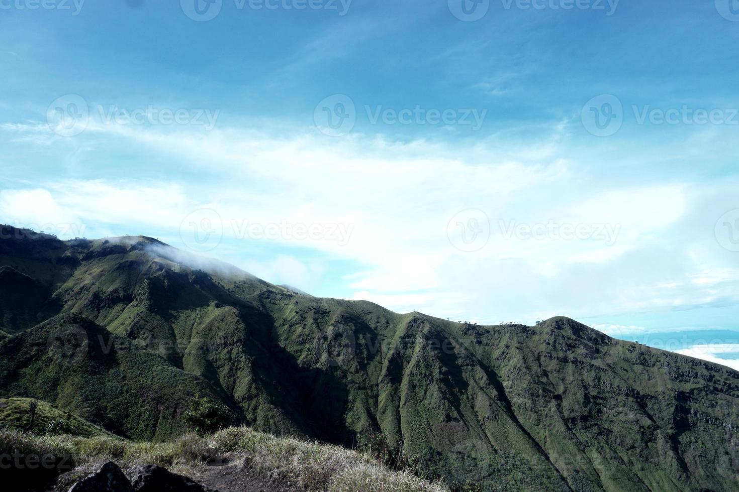 Green mountains and beautiful sky clouds under blue sky photo