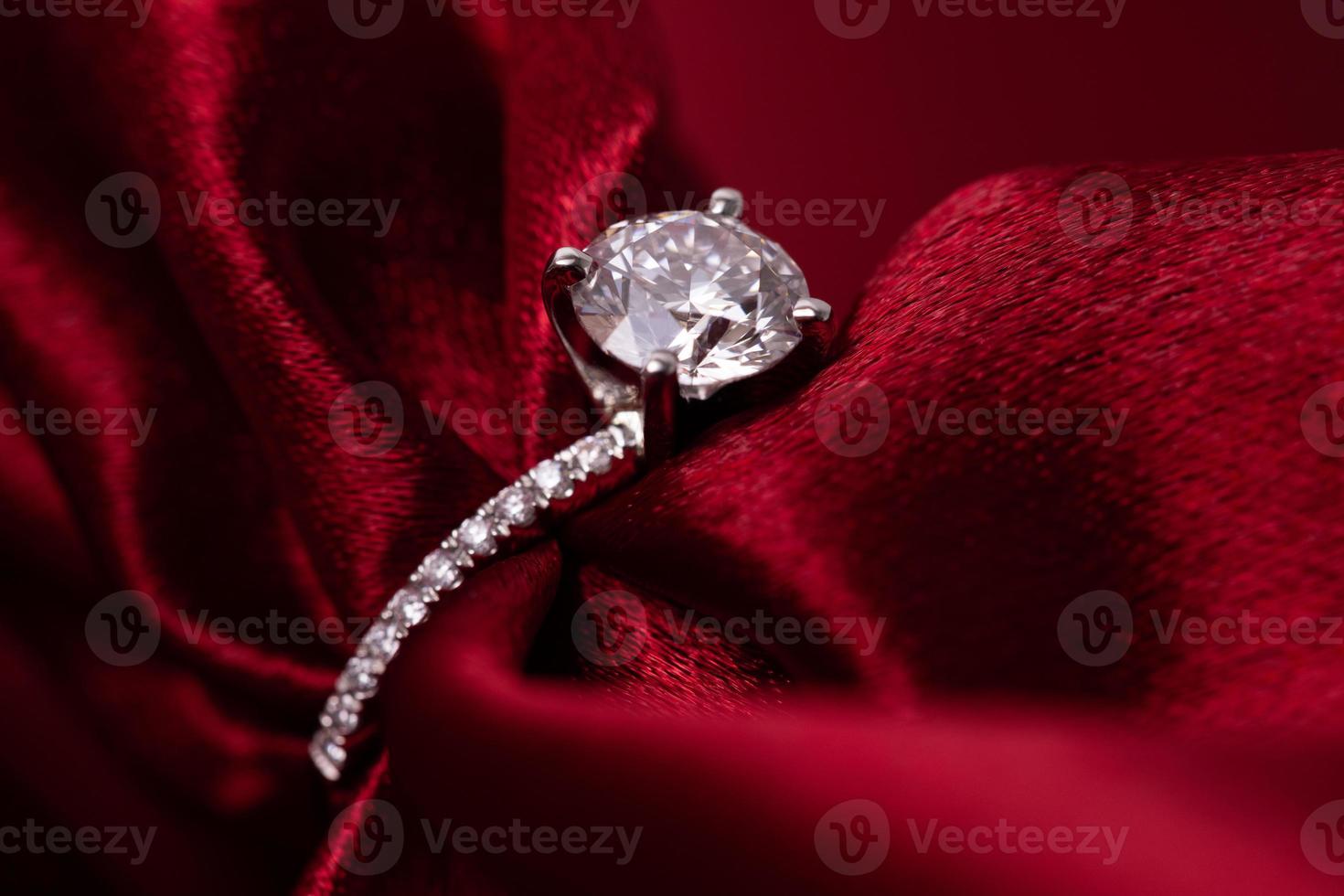 anillo de bodas de diamantes tela roja foto