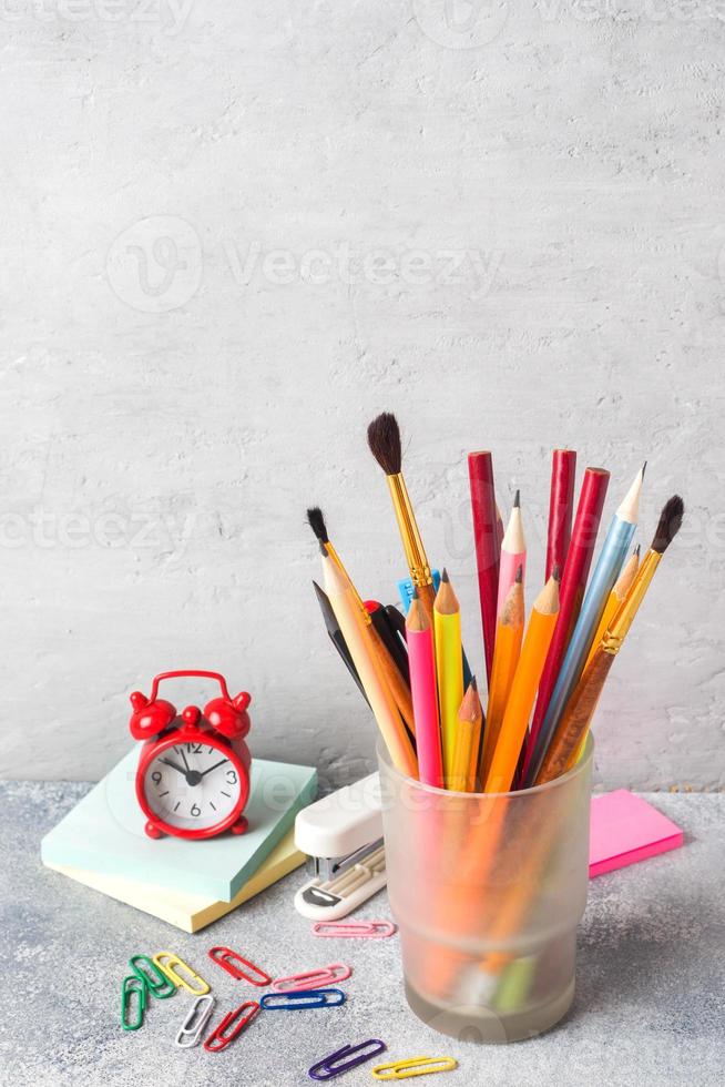 School supplies, a set of pencil markers in a glass on a gray table with a copy of space. Concept school. photo
